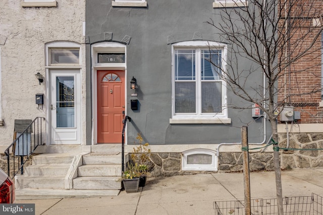 doorway to property featuring stucco siding