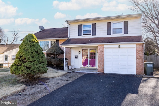 view of front of property featuring an attached garage, brick siding, roof with shingles, and driveway