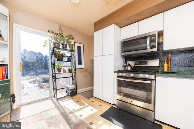 kitchen featuring white cabinetry, dark countertops, tasteful backsplash, and stainless steel appliances