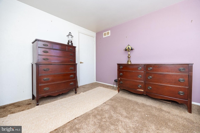 bedroom featuring baseboards, visible vents, and light carpet