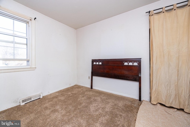 unfurnished bedroom with visible vents and carpet