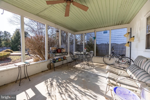 unfurnished sunroom featuring ceiling fan