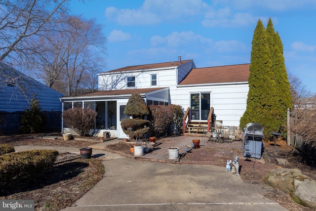 back of property with a patio, entry steps, and a sunroom