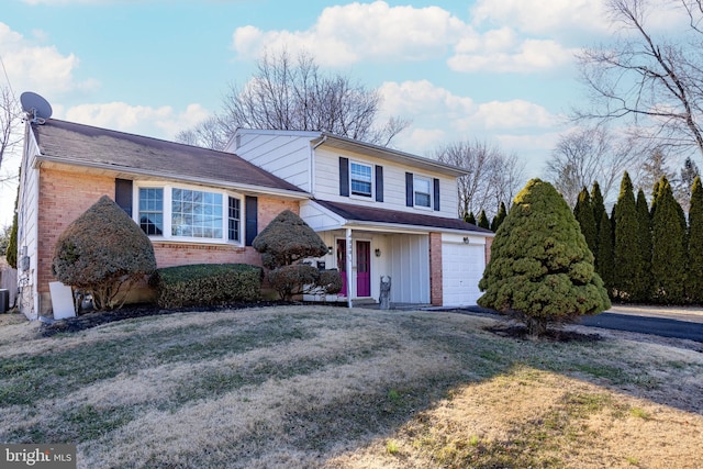 view of front of house with a front lawn, brick siding, and a garage