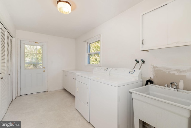 laundry area featuring washer and dryer, cabinet space, and a sink