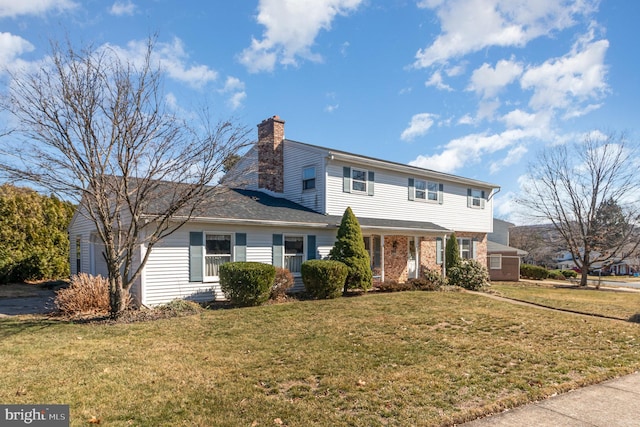 view of front of property with a front yard, brick siding, and a chimney