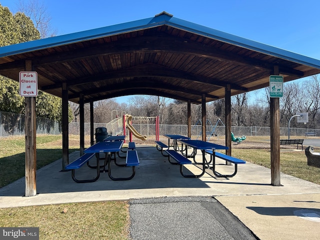 view of property's community with playground community and fence