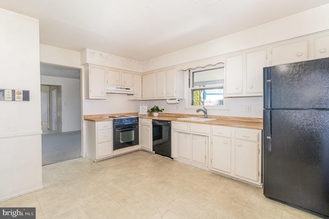 kitchen with black appliances, wooden counters, under cabinet range hood, and a sink