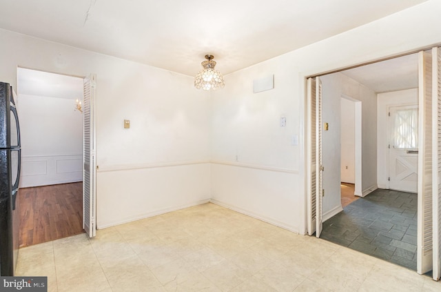 unfurnished room featuring a notable chandelier