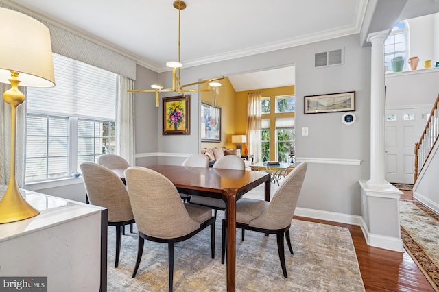 dining room featuring visible vents, ornamental molding, wood finished floors, and decorative columns