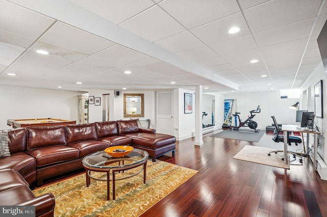 living room featuring dark wood finished floors, a drop ceiling, and recessed lighting