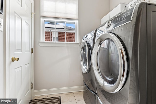 laundry area featuring laundry area, light tile patterned floors, baseboards, and independent washer and dryer