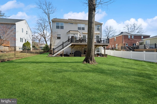 back of property featuring stairway, a fenced backyard, a yard, and a deck