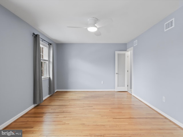 empty room featuring visible vents, ceiling fan, baseboards, and light wood-style floors