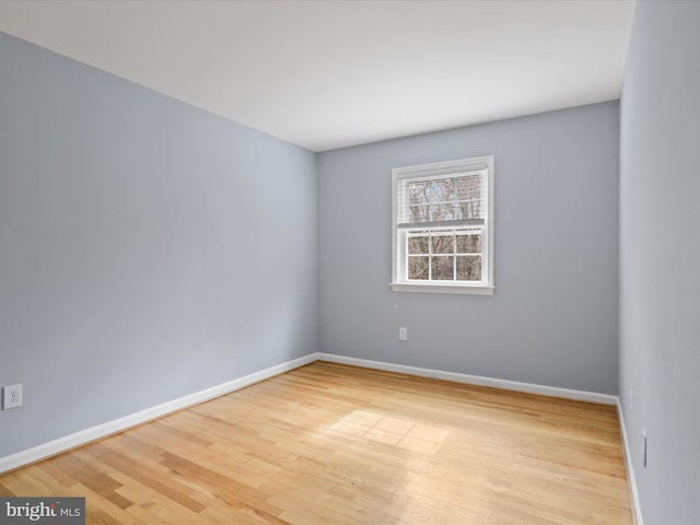 spare room featuring baseboards and wood finished floors