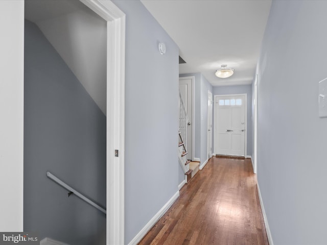 hallway featuring stairway, baseboards, and wood finished floors