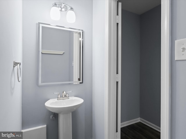 bathroom featuring a sink, baseboards, and wood finished floors