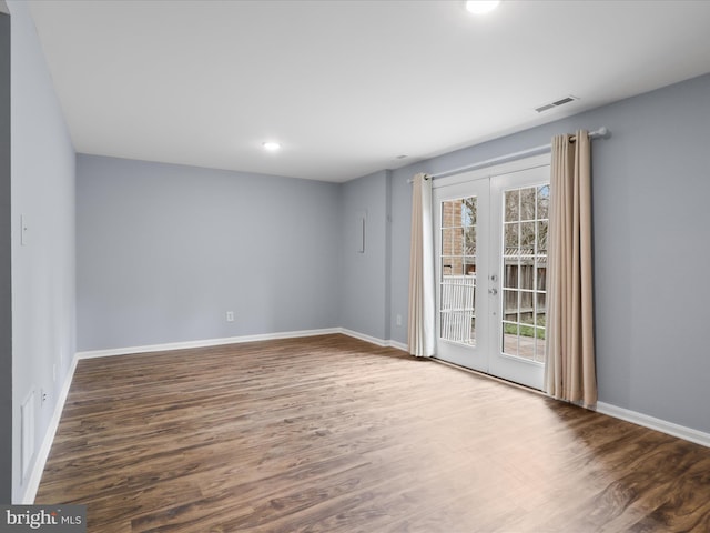 empty room with visible vents, baseboards, wood finished floors, and french doors