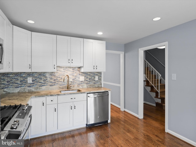 kitchen featuring tasteful backsplash, dark wood finished floors, appliances with stainless steel finishes, white cabinetry, and a sink