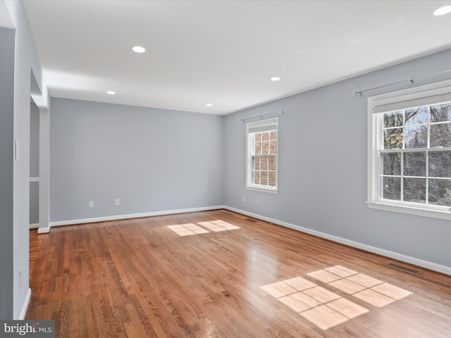 spare room with recessed lighting, baseboards, and wood finished floors