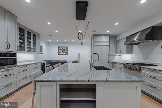 kitchen featuring open shelves, wall chimney range hood, appliances with stainless steel finishes, and gray cabinetry