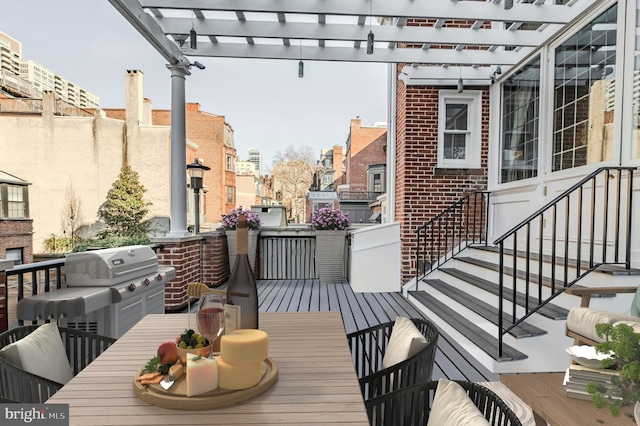 view of wooden balcony featuring outdoor dining space, entry steps, a pergola, and a deck