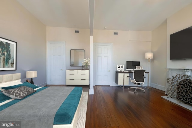 bedroom featuring visible vents, baseboards, and wood finished floors