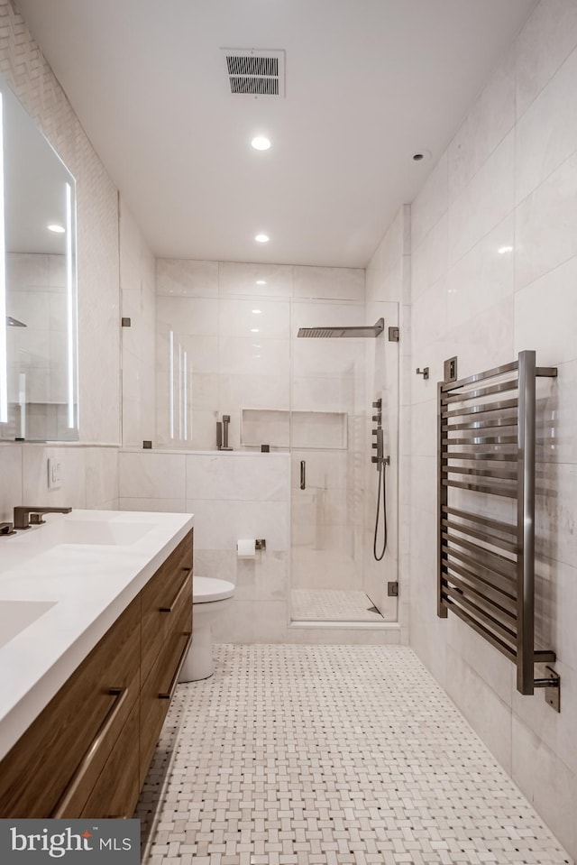 full bathroom featuring visible vents, radiator heating unit, a stall shower, tile walls, and a sink