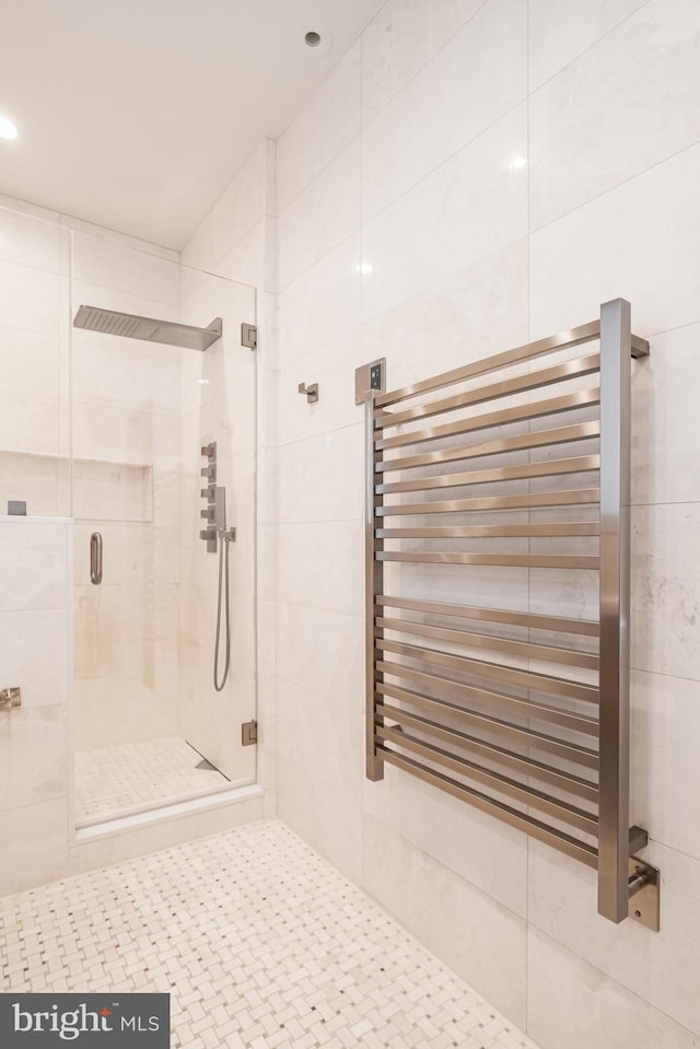 full bath featuring tile patterned floors, radiator heating unit, and a stall shower