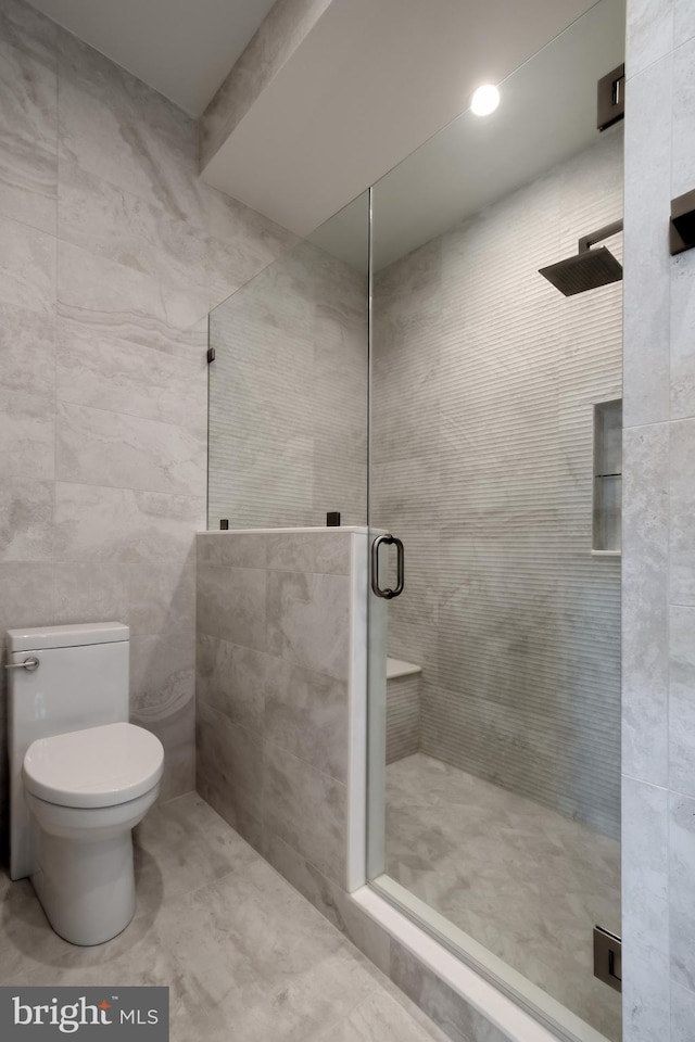 full bathroom with toilet, tile walls, and a stall shower