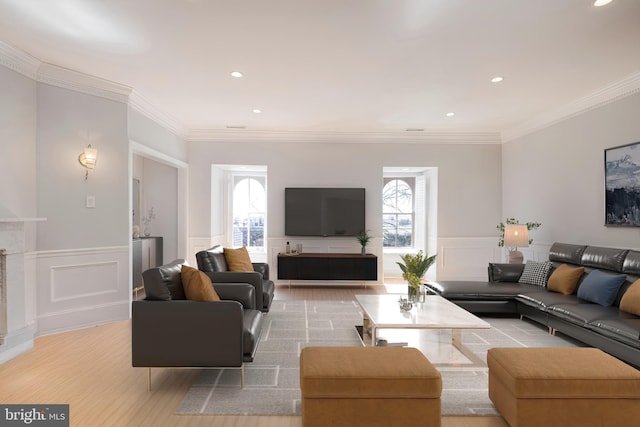 living room with crown molding, a decorative wall, recessed lighting, and a wainscoted wall