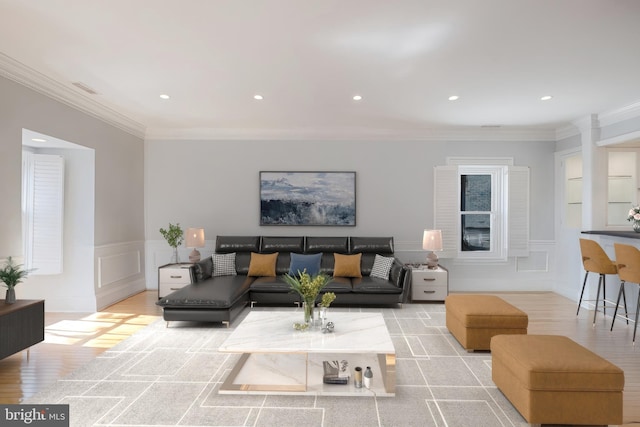 living area featuring recessed lighting, light wood finished floors, ornamental molding, and a decorative wall