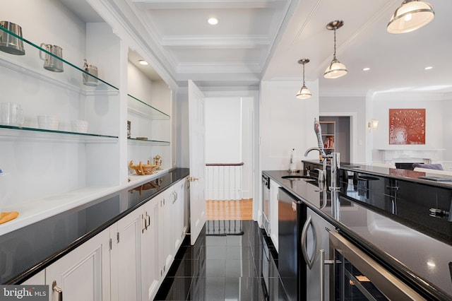 kitchen with ornamental molding, a sink, white cabinets, pendant lighting, and dark countertops