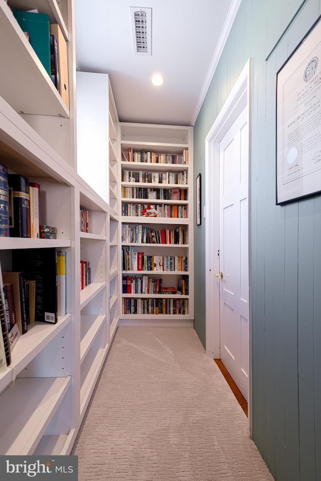 corridor featuring visible vents, carpet floors, and ornamental molding