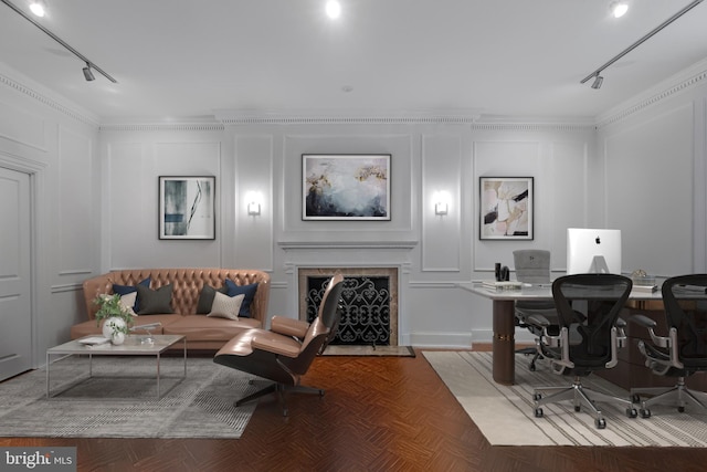 office area with a decorative wall, a fireplace, track lighting, and crown molding