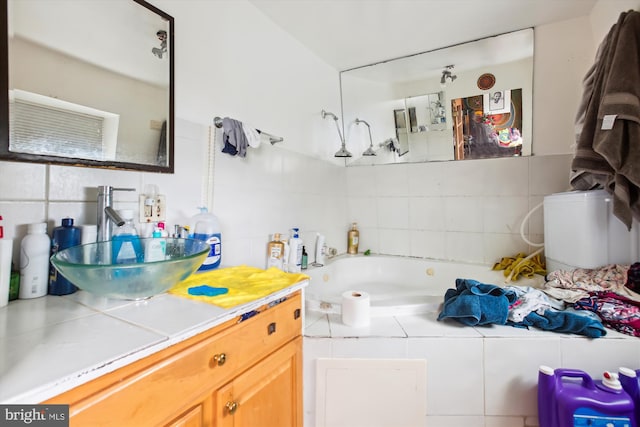 full bath with tasteful backsplash, vanity, tile walls, and a garden tub