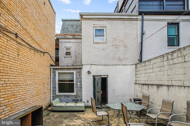 back of house with a patio area and brick siding