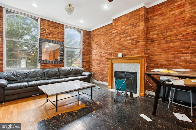 living room featuring ornamental molding, hardwood / wood-style flooring, recessed lighting, brick wall, and a fireplace