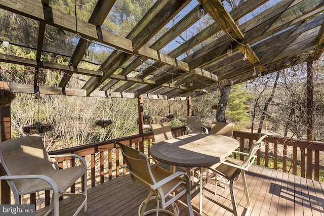 wooden terrace with a pergola and outdoor dining area