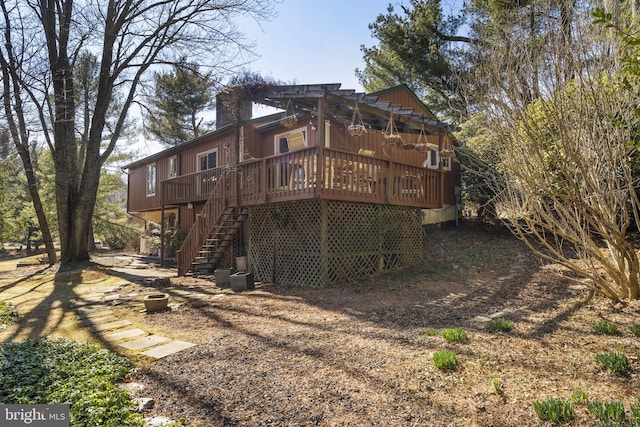 back of property with a deck, stairway, and a chimney