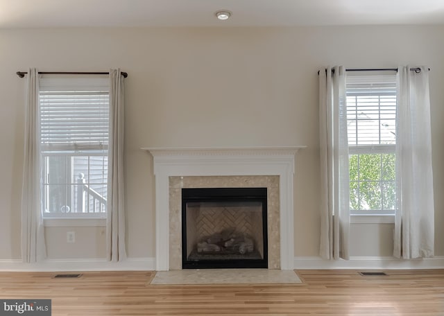 room details featuring a fireplace with flush hearth, wood finished floors, and visible vents