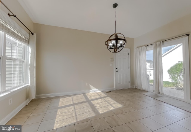 unfurnished dining area featuring a wealth of natural light, a notable chandelier, and light tile patterned floors
