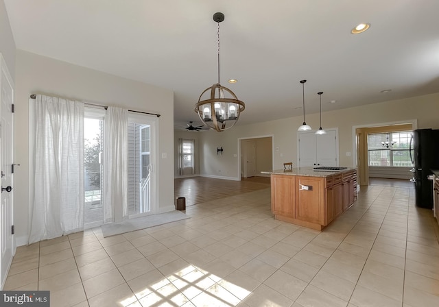 kitchen with stainless steel gas cooktop, baseboards, freestanding refrigerator, recessed lighting, and light tile patterned floors