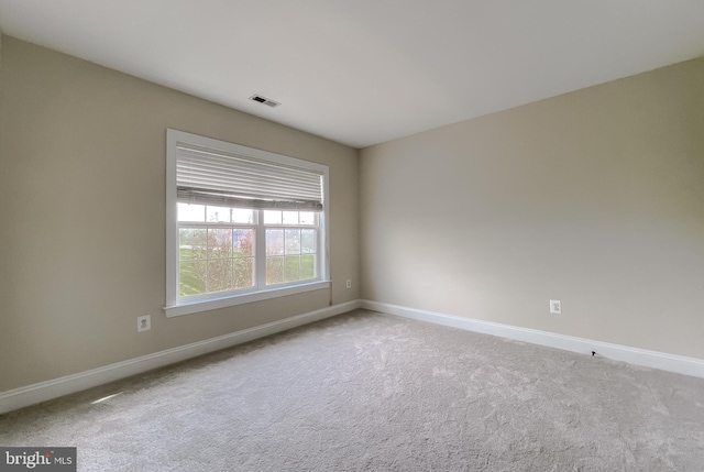 spare room featuring baseboards, visible vents, and carpet flooring