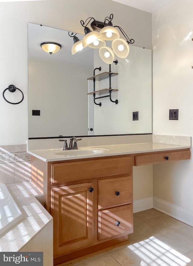 bathroom with tile patterned floors, tiled tub, vanity, and baseboards