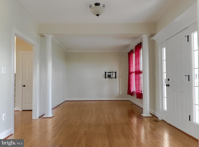 entryway featuring light wood-style floors, crown molding, baseboards, and decorative columns