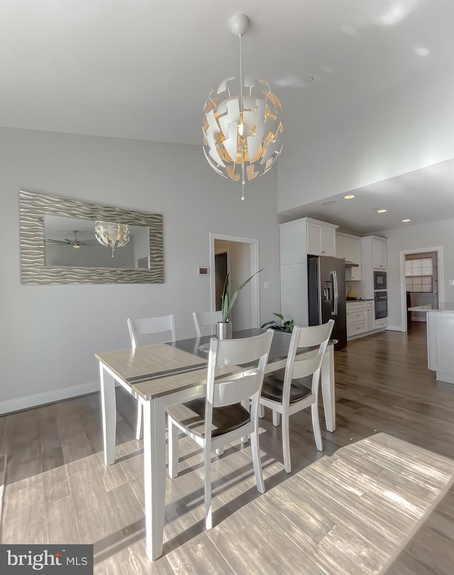 dining room with a chandelier, recessed lighting, baseboards, and wood finished floors