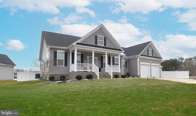 view of front of house with driveway, a porch, fence, a front yard, and a garage