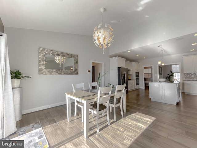 dining room featuring recessed lighting, a notable chandelier, light wood-style floors, and baseboards