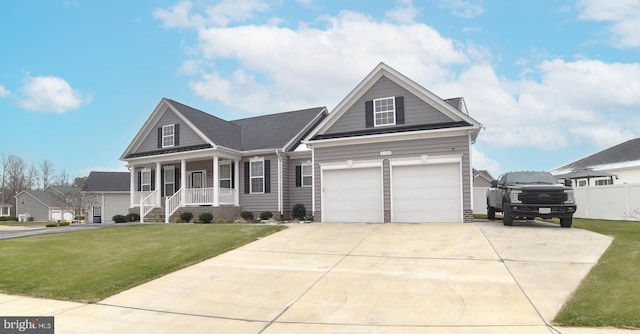 view of front facade with driveway, an attached garage, covered porch, and a front yard